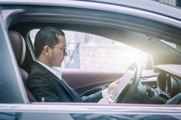 Business men work with tablet computers in their cars