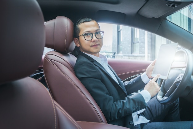 Business men work with tablet computers in their cars