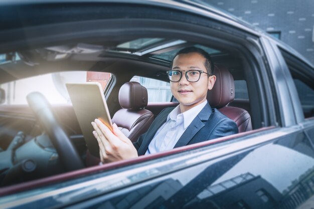 Business men work with tablet computers in their cars