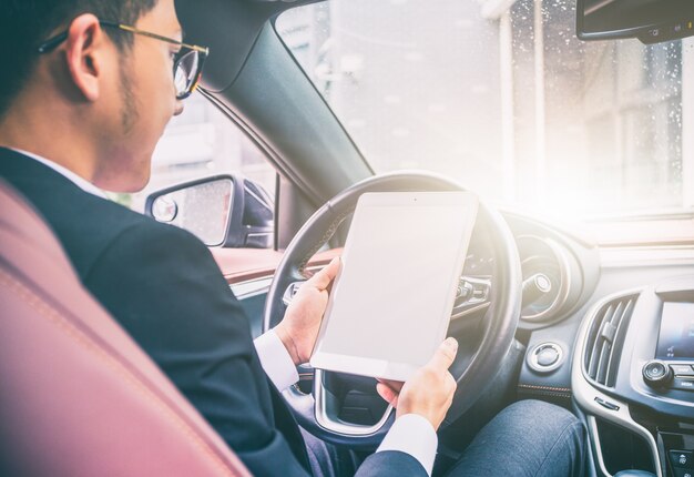 Business men work with tablet computers in their cars