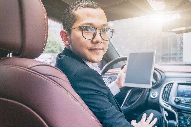 Business men work with tablet computers in their cars