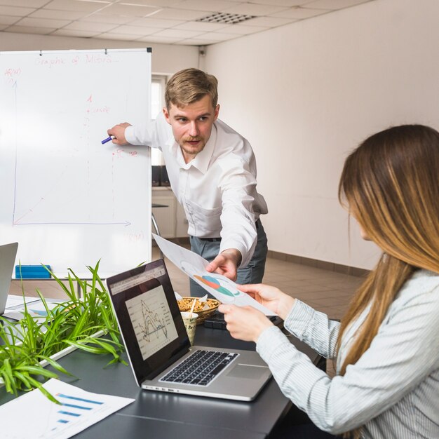 Business partner passing graph to his female manager