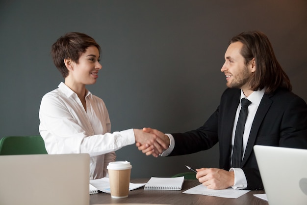 Business partners greeting with handshake during office meeting