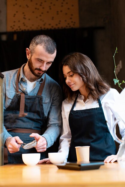 Business partners learning how to make coffee