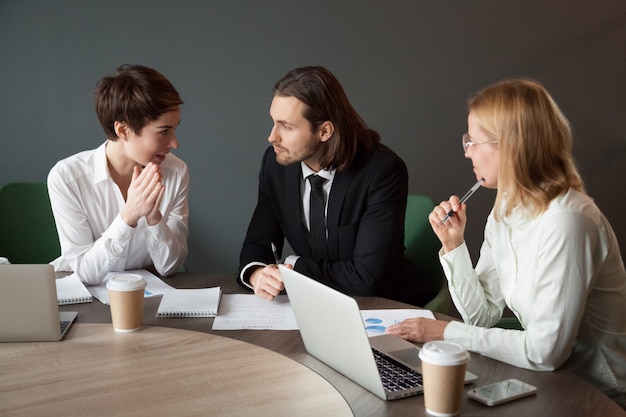 Business partners negotiating about project during meeting in boardroom