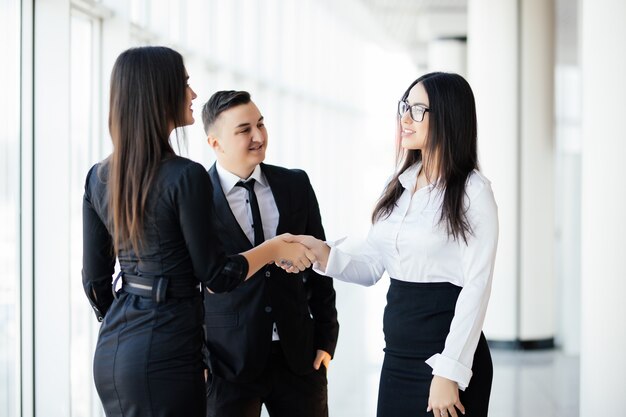 Business partners shaking hands in meeting hall. Two business woman greetings handshake in office