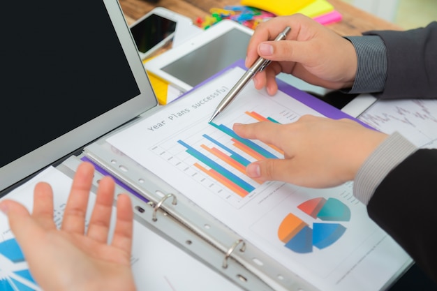 Business people analyzing a bar chart with a pen