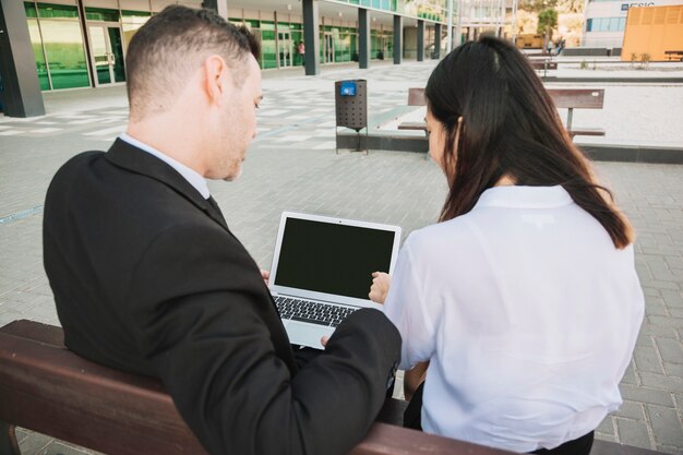 Business people on bench with laptop
