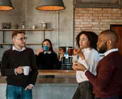 Foto gratuita uomini d'affari che mangiano pizza e caffè durante una pausa di riunione in ufficio