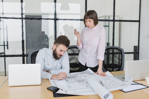 Free photo business people looking at plans in office