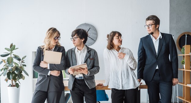 事務所に立っているビジネス人々が話し合う