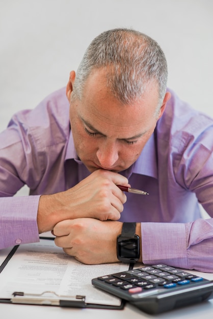 Free photo business person thinking hard about tax. taxation concept. photo of young depressed businessman sitting in office