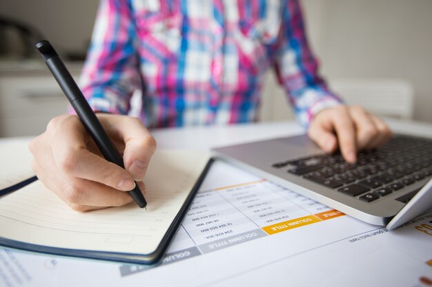 Business Person Working on Laptop and Making Notes