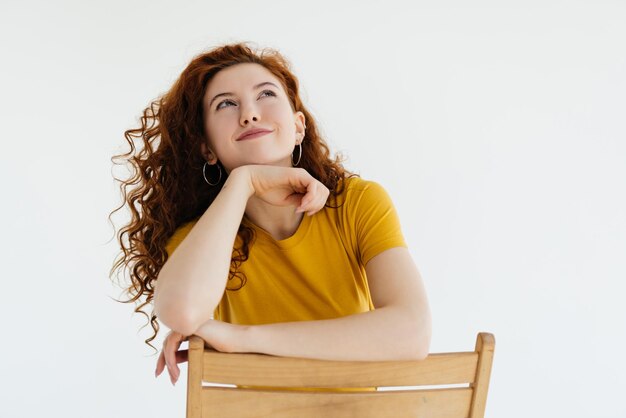 Business portrait of beautiful young woman with red curly hair against white background Lifestyle