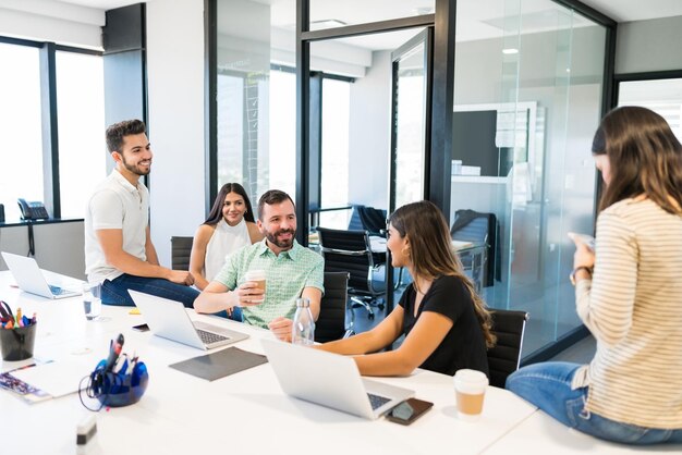 Business professionals talking during coffee break at office desk