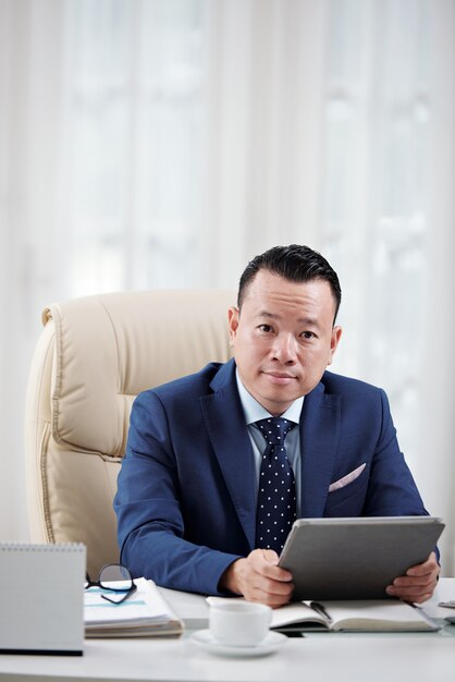 Business representative sitting in the light office with digital tablet