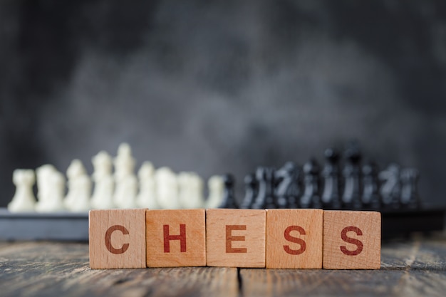 체스 판과 인물, 안개와 나무 테이블 측면보기에 나무 큐브와 비즈니스 전략 개념.