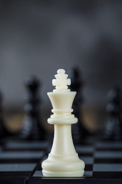 Business strategy concept with figures on chessboard on blurred and wooden table close-up.
