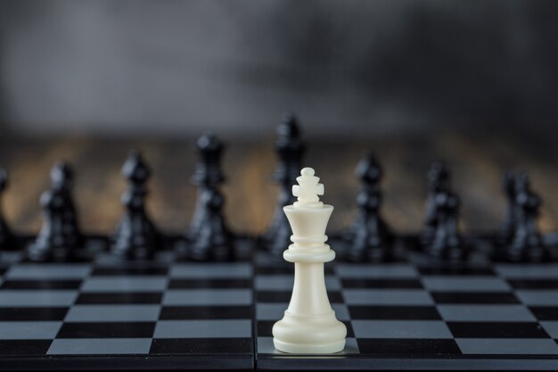 흐리게 및 나무 테이블 측면보기에 체스 판에 수치와 비즈니스 전략 개념.