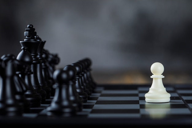 Free photo business strategy concept with figures on chessboard on foggy and wooden table side view.