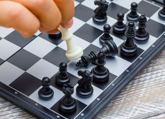 Business strategy concept on wooden background hand moving chess figure in competition.