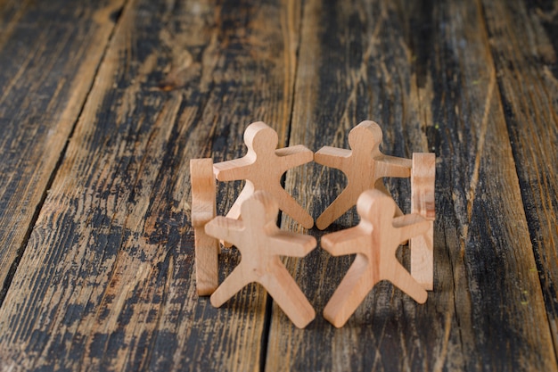 Business success and teamwork concept with wooden figures of people on wooden table top view.