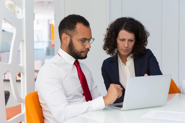 Business team of two using computer together