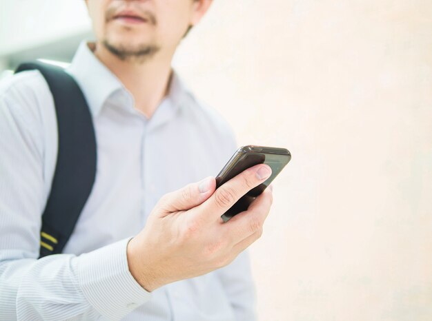 Business traveler using mobile phone during his journey at airport terminal