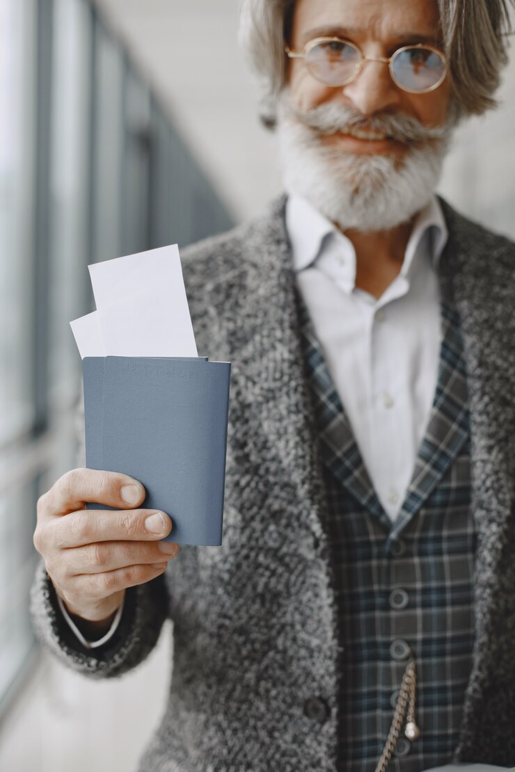 Free Photo business trip. corporate and people concept. male in a gray coat. senior wit a passport.