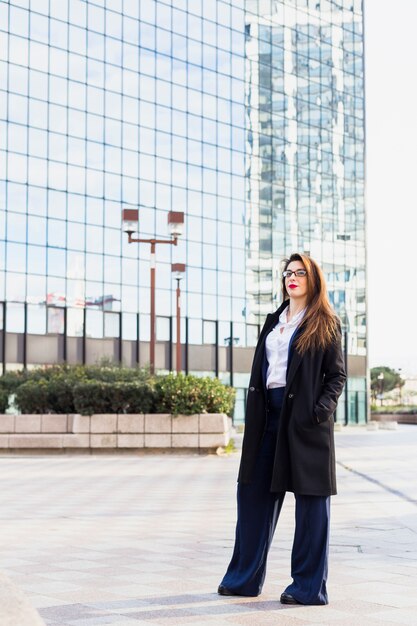 Business woman in black jacket standing outside 