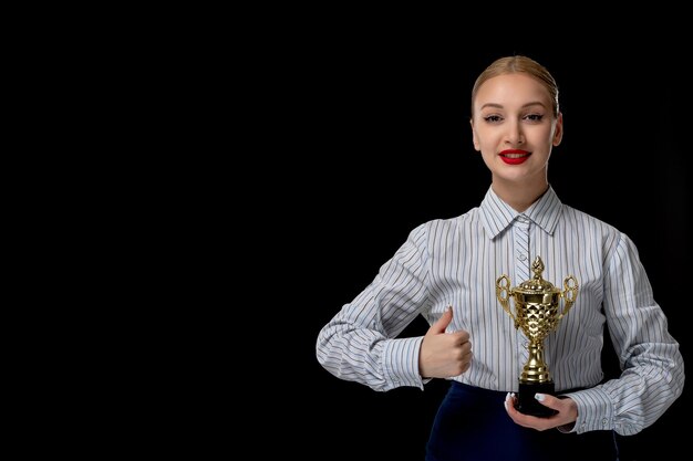 Business woman blonde happy cute girl holding trophy with red lipstick in office suit