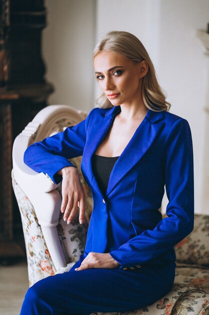 Business woman in blue suit standing by the window