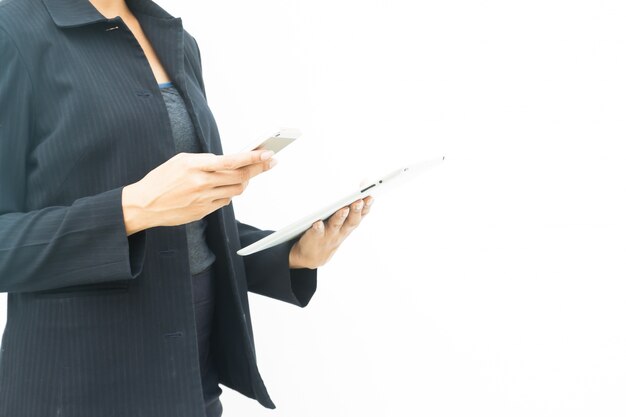 Business woman in dark suit using her tablet and mobile phone on white background with copy space