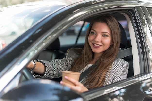 ビジネスの女性が車を運転