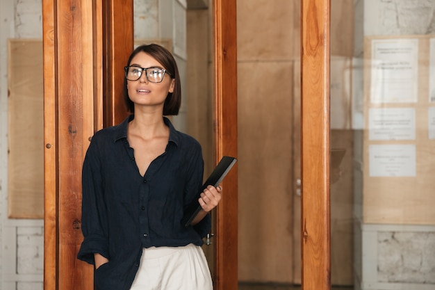 Business woman in eyeglases with folder in hand