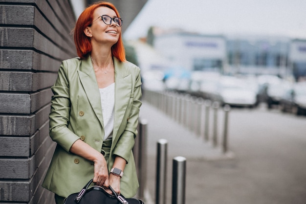 Business woman in green suit standing by the wall