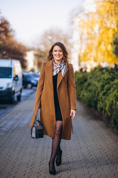 Деловая женщина счастлива в пальто на улице