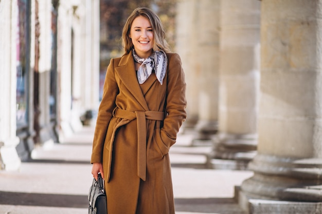 Business woman happy in coat in the street