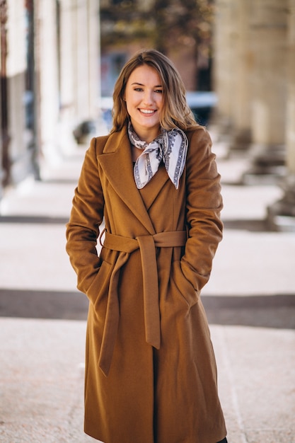 Donna d'affari felice in cappotto in strada