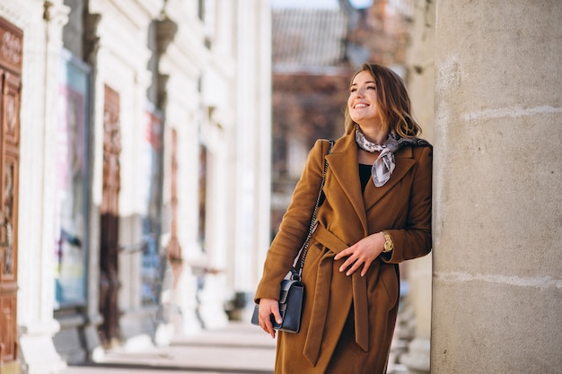 Business woman happy in coat in the street