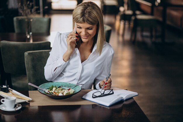 ビジネスの女性がカフェで昼食をとった