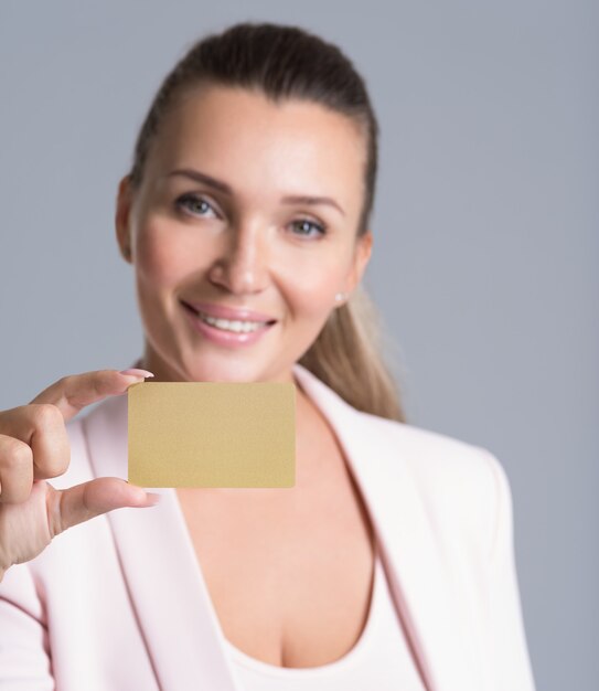 Business woman holding credit card against her face isolated studio portrait