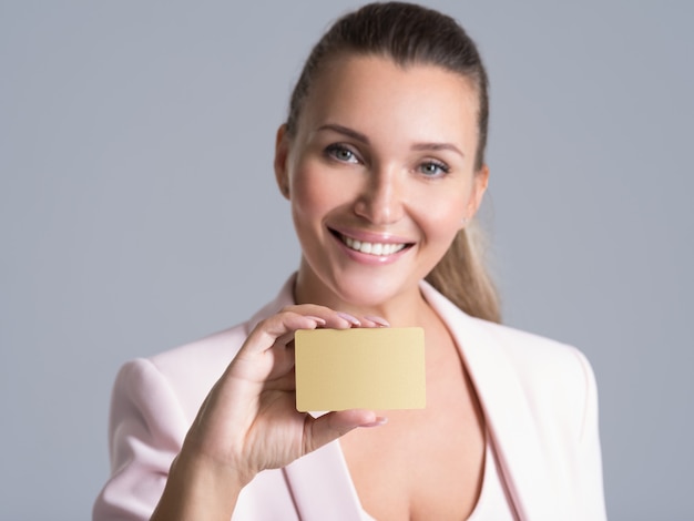 Business woman holding credit card against her face isolated studio portrait