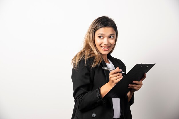 Business woman holding document on clipboard .