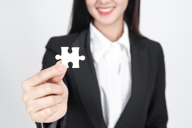 business woman  holding and showing  a jigsaw puzzle