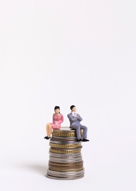 Business woman and man sitting on a pile of coins front view