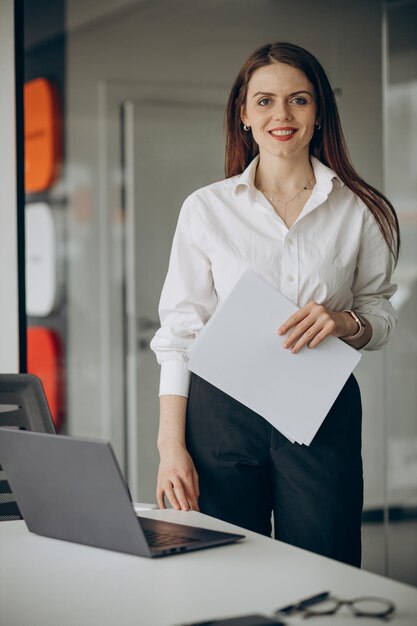 Business woman at office standing by a computer