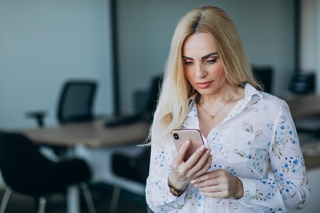 Donna di affari in ufficio facendo uso del telefono