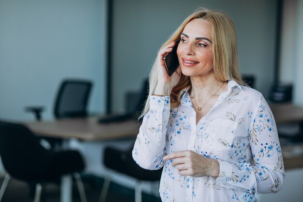 Business woman in office using phone