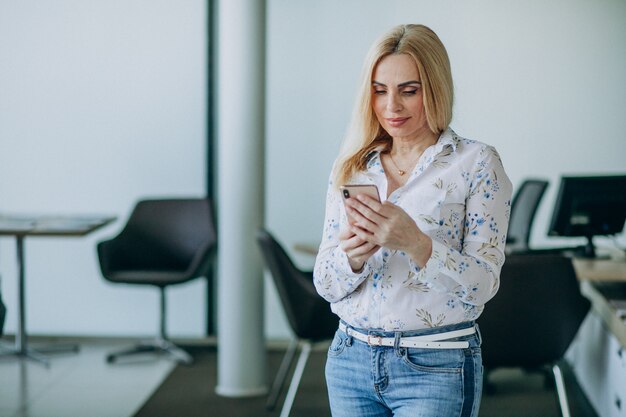 Business woman in office using phone